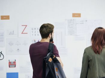 Eine Frau und ein Mann vor einer Informations-Wand