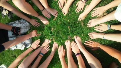 Füße und Hände bilden einen Kreis auf einer Wiese